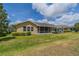 Expansive backyard features a screened lanai, lush lawn, and vibrant landscaping at 2286 Sifield Greens Way # 2286, Sun City Center, FL 33573
