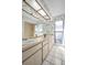 Well-lit bathroom with dual sinks, large mirror, and floral wallpaper at 2462 Indian E Trl, Palm Harbor, FL 34683