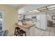 Bright kitchen with white cabinets, breakfast bar, and views to the dining room and backyard at 2462 Indian E Trl, Palm Harbor, FL 34683