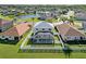Aerial shot of home featuring a screened-in pool, white picket fence and lush green grass at 25631 Bruford Blvd, Land O Lakes, FL 34639