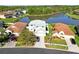 Aerial view of a two-story home, nestled lakeside and surrounded by lush greenery at 25631 Bruford Blvd, Land O Lakes, FL 34639