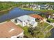 A birds eye view of a suburban home surrounded by a pond, with lush landscaping at 25631 Bruford Blvd, Land O Lakes, FL 34639