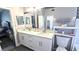 Bathroom featuring white cabinets, double sinks, and decorative mosaic tile at 25631 Bruford Blvd, Land O Lakes, FL 34639
