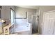 Beautiful bathroom featuring a soaking tub and shower with patterned tile at 25631 Bruford Blvd, Land O Lakes, FL 34639