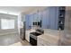 Stylish kitchen showcasing blue cabinets, a mosaic backsplash, and stainless steel appliances at 25631 Bruford Blvd, Land O Lakes, FL 34639