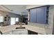 Open kitchen view with quartz countertops, blue cabinets and flowing into the living area at 25631 Bruford Blvd, Land O Lakes, FL 34639