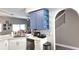 Bright kitchen with light countertops, white cabinets and blue upper cabinets, next to a staircase at 25631 Bruford Blvd, Land O Lakes, FL 34639