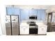 Bright kitchen with blue cabinets, stainless steel appliances, and modern countertops at 25631 Bruford Blvd, Land O Lakes, FL 34639