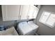 A laundry room features white washer and dryer, overhead cabinets, utility sink, and hardwood flooring at 25631 Bruford Blvd, Land O Lakes, FL 34639