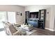 Bright living room with comfortable seating, a decorative coffee table, and a stylish entertainment center near a large window at 25631 Bruford Blvd, Land O Lakes, FL 34639