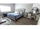 Bright main bedroom with a plush bed, dressing table, and wood-look floors at 25631 Bruford Blvd, Land O Lakes, FL 34639
