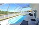 View of screened in pool featuring a waterfront view and outdoor patio furniture at 25631 Bruford Blvd, Land O Lakes, FL 34639