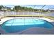An eye level shot of a bright blue screened-in pool overlooking a tranquil pond at 25631 Bruford Blvd, Land O Lakes, FL 34639