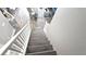 Staircase with wood steps and white railing leads to a living area with wood flooring at 25631 Bruford Blvd, Land O Lakes, FL 34639