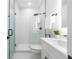 Modern bathroom features a glass-enclosed shower, white vanity with black hardware, and neutral tones at 2608 W Saint Joseph St # 2, Tampa, FL 33607