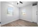Bright bedroom with neutral walls, wood-look flooring, two windows, and built-in storage cabinets at 2608 W Saint Joseph St # 2, Tampa, FL 33607