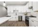 Bright kitchen with stainless steel appliances, white cabinets, and stone backsplash at 2608 W Saint Joseph St # 2, Tampa, FL 33607