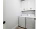 Laundry room with white washer and dryer and overhead cabinets at 2608 W Saint Joseph St # 2, Tampa, FL 33607