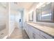 Modern bathroom featuring double vanity, granite countertop, decorative mirrors, and walk-in glass shower at 2671 Murray Pass, Odessa, FL 33556