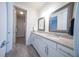 Bathroom with double vanities, gray and white granite countertop and wooden-framed mirrors, with wood-look tile flooring at 2671 Murray Pass, Odessa, FL 33556
