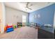 Bright bedroom with a blue wall and neutral decor, a gray crib, and carpeted floors with ceiling fan at 2671 Murray Pass, Odessa, FL 33556