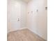 Inviting entryway featuring wood-look tile flooring, white shiplap wall accents, and hooks for coats and bags at 2671 Murray Pass, Odessa, FL 33556