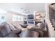 Cozy living room with sofa, a stone fireplace, shelves, electric fireplace, and a ceiling fan at 2671 Murray Pass, Odessa, FL 33556