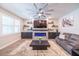 Bright living room with a fireplace, media console, ceiling fan, floating shelves, and hardwood floors at 2671 Murray Pass, Odessa, FL 33556