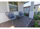 Cozy front porch seating area with two chairs, a side table, and view of the surrounding landscape at 2671 Murray Pass, Odessa, FL 33556