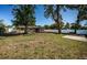 Spacious backyard enclosed by white fencing with mature trees offers privacy and room to play at 2707 Morningside Dr, Clearwater, FL 33759