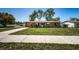 Inviting single-story home features a well-kept lawn, a long driveway, and mature trees at 2707 Morningside Dr, Clearwater, FL 33759