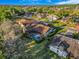An aerial view of houses with pools in a neighborhood surrounded by lush greenery and well-maintained landscaping at 2806 Forest Club Dr, Plant City, FL 33566