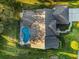Stunning aerial view of a home with a screened-in pool surrounded by lush green landscaping and a pristine roof at 2806 Forest Club Dr, Plant City, FL 33566