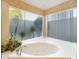 Luxurious bathtub with privacy screen and lush garden view, perfect for relaxation at 2806 Forest Club Dr, Plant City, FL 33566