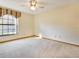 Neutral-toned bedroom featuring soft carpet, natural light, and a classic ceiling fan at 2806 Forest Club Dr, Plant City, FL 33566