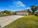 Wide driveway leading to a home with a three-car garage and mature landscaping at 2806 Forest Club Dr, Plant City, FL 33566