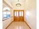 Inviting foyer with a decorative chandelier, double wooden doors, and tile flooring, creating an elegant entry at 2806 Forest Club Dr, Plant City, FL 33566