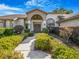 A home's front entrance features manicured hedges and a walkway to the front door at 2806 Forest Club Dr, Plant City, FL 33566