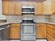 Modern stainless steel appliances including an oven and microwave, set amongst light wood cabinetry and neutral backsplash at 2806 Forest Club Dr, Plant City, FL 33566