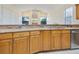 Kitchen featuring granite countertops, wooden cabinets, and stainless steel dishwasher in an open layout at 2806 Forest Club Dr, Plant City, FL 33566