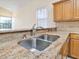 Well-lit kitchen sink featuring granite countertops and stainless steel faucet, with light wood cabinets above at 2806 Forest Club Dr, Plant City, FL 33566