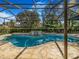 Inviting outdoor pool with a screened enclosure, surrounded by lush greenery and a landscaped yard at 2806 Forest Club Dr, Plant City, FL 33566