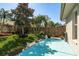 Well-maintained backyard with a blue patio, manicured lawn, landscaping, and privacy fence at 2991 Covewood Pl, Clearwater, FL 33761