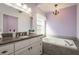 Bathroom with a granite countertop vanity, a bathtub, and a window at 2991 Covewood Pl, Clearwater, FL 33761