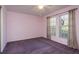 Empty bedroom with neutral walls, two large windows, and purple carpeting at 2991 Covewood Pl, Clearwater, FL 33761
