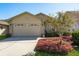 Well-maintained home exterior with a wide driveway, lush landscaping, and a two-car garage at 2991 Covewood Pl, Clearwater, FL 33761