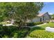 Well-maintained single-Gathering home with lush landscaping, including mature trees and manicured shrubs, creating a welcoming curb appeal at 2991 Covewood Pl, Clearwater, FL 33761