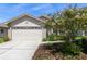 Charming single-Gathering home featuring a manicured lawn, a two-car garage, and a beautifully landscaped front yard with mature trees at 2991 Covewood Pl, Clearwater, FL 33761