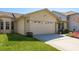 Front view of a two-car garage with decorative windows and a well-maintained lawn at 2991 Covewood Pl, Clearwater, FL 33761