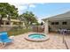 Enjoy a relaxing soak in this cozy, round hot tub with a paver surround and lush landscaping at 2991 Covewood Pl, Clearwater, FL 33761